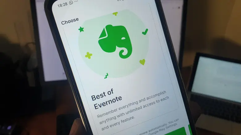 شخصی که گوشی را در دست دارد و برنامه Evernote باز است