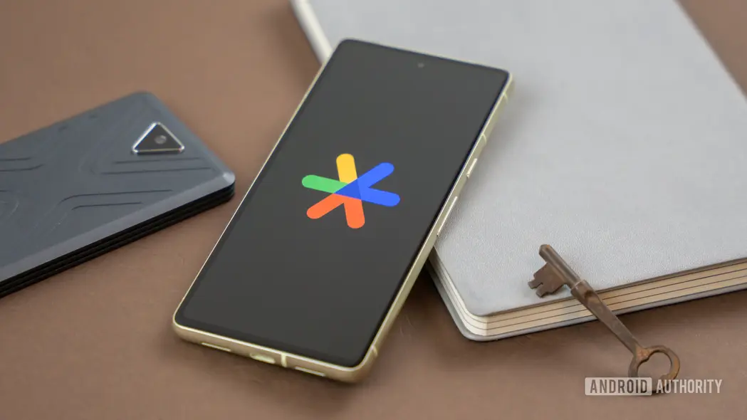 لوگوی Google Authenticator بر روی گوشی هوشمند در کنار سایر لوازم (عکس استوک ۱)