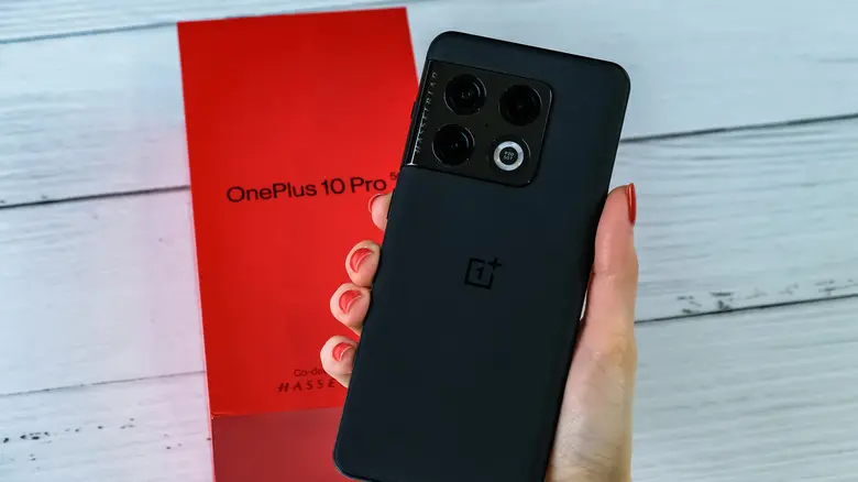 فردی که گوشی سیاه OnePlus را در دست دارد
