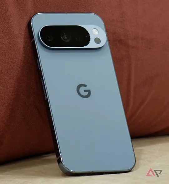 Pixel 10 Pro که بهسوی یک کوسن صورتی تکیه داده است