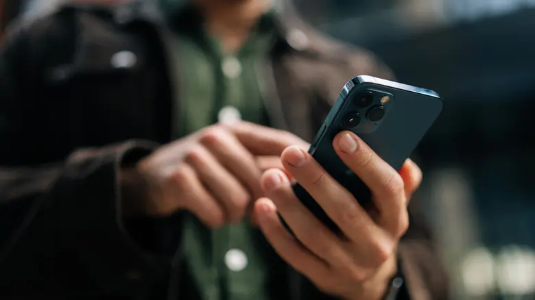 دستهای نگهدارنده یک تلفن همراه.