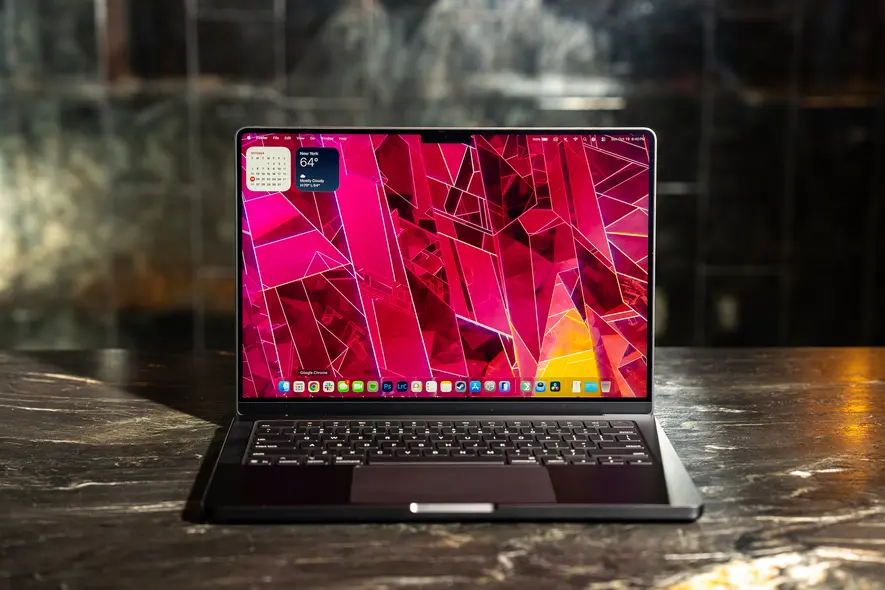 MacBook Pro 14‑اینچی 2025 مدل M5 بر روی یک بار سنگ مرمر با بازتاب تاریک در پشت