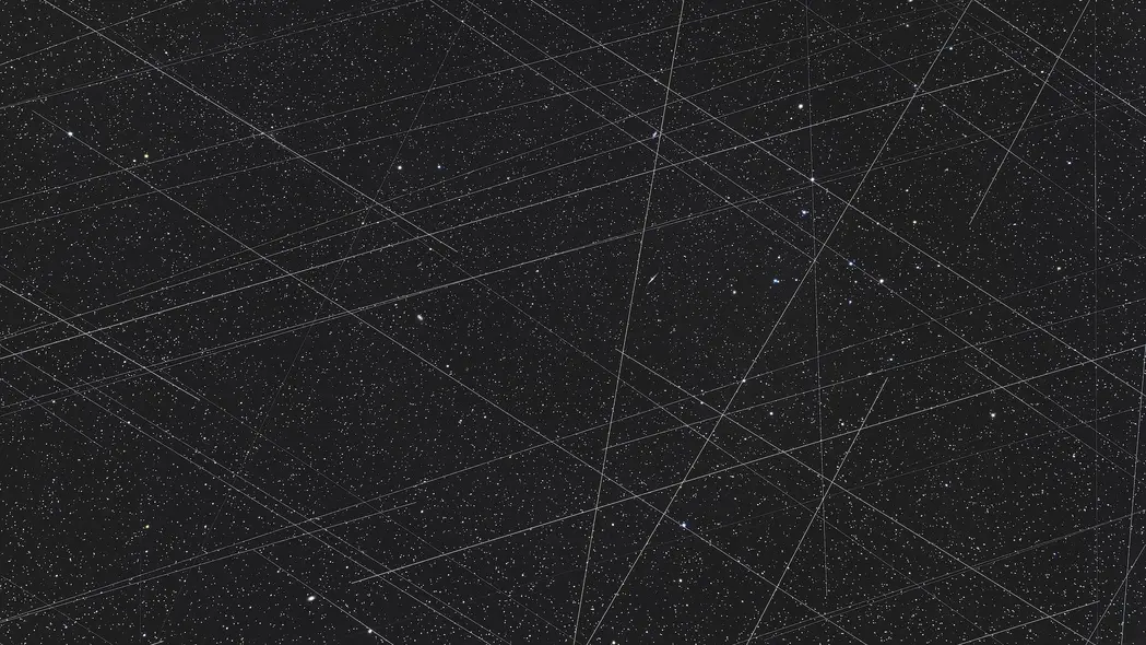 عکسی از آسمان شب با ردپای زیگزاگهای بهدست ماهوارهها