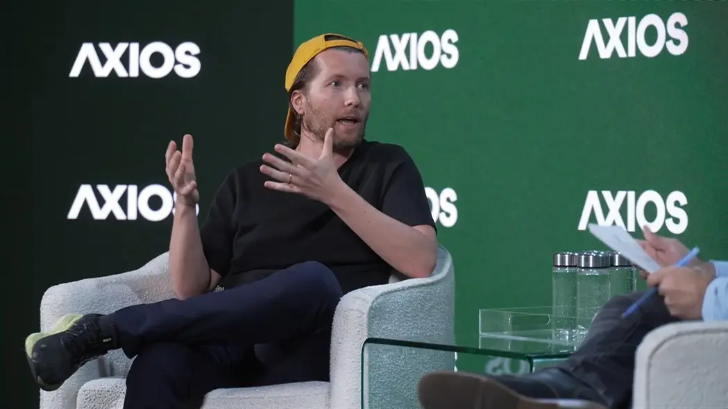 مردی با کلاه بیسبال روی صحنه سخن میگوید و با حرکات دست توضیح میدهد