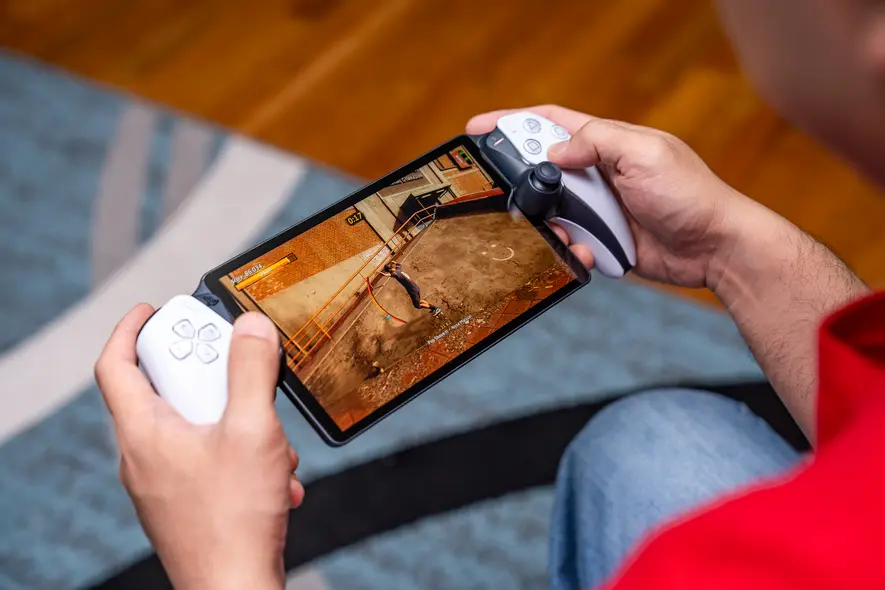 شخصی که پورتال پلیاستیشن را در دست گرفته و با Remote Play بازی تونی هاک پرو اسکیتر 1 + 2 را اجرا میکند.