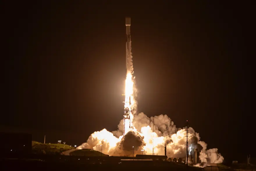 تصویری از شعله‌ سوزن و بخار آب ناشی از پرتاب موشک Falcon 9 شرکت SpaceX از پایگاه پرتاب فضایی ۴ شرق در پایگاه فضایی ون‌دربرج، کالیفرنیا.